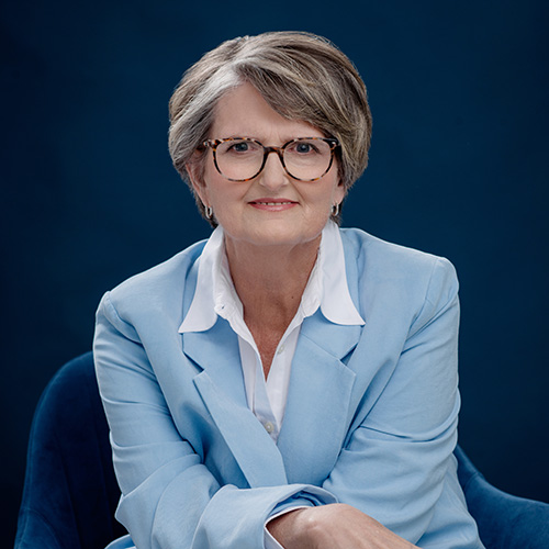 Deborah Hocutt headshot wearing a light blue suit jacket against a dark blue backgroun